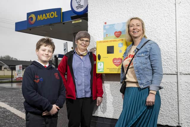 Michelle Hunter, Assistant Manager at Route Service Station with Leanne Stewart Murray and her son, Elliott Murray with the defibrillator at Route Service Station that has been installed in Paul Murray’s memory