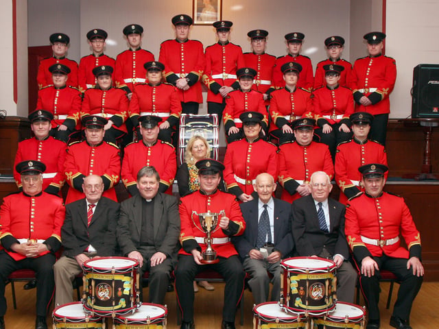 Members of the Churchill Flute Band, pictured at the dedication and presentation of a band cup in memory of band member Drew Porter, held in the Apprentice Boys Memorial Hall, Londonderry. Included seated (second from left) are Derek Nutt, band chairman, the Dean of Derry Very Rev. William Morton, Simon Mowbray, bandmaster, Walter McLaughlin, president and James Thompson, vice-chairman. INLS 1214-515MT.