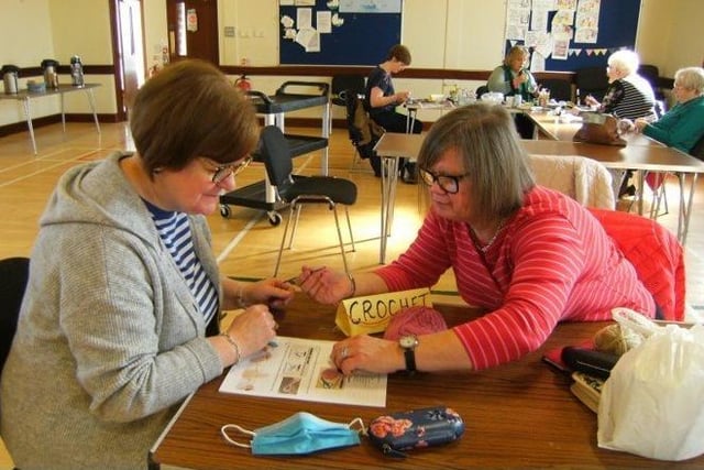 Lena McKeeman helping Ruth McQuitty with crocheting