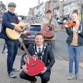 Lord Mayor Glenn Barr and BBC Radio Ulster's Ralph McLean with young buskers in Banbridge ahead of the return of Buskfest on May 21