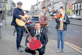 Lord Mayor Glenn Barr and BBC Radio Ulster's Ralph McLean with young buskers in Banbridge ahead of the return of Buskfest on May 21