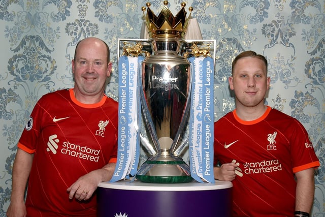 Proudly posing with the English Premier League trophy when it was on display at Charlie McKeever's Bar last week are Liverpool supporters, Paul, left, and Joshua Gilmore from Waringstown. INPT18-200.