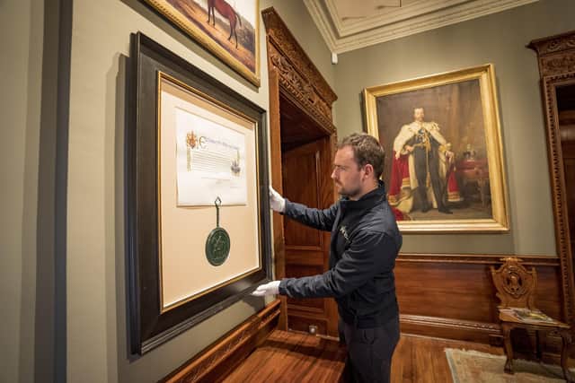 David Orr, Castle and Collections Manager at Hillsborough Castle is pictured making the final adjustments to the mounted patent in the Ante Room, in the heart of the castle