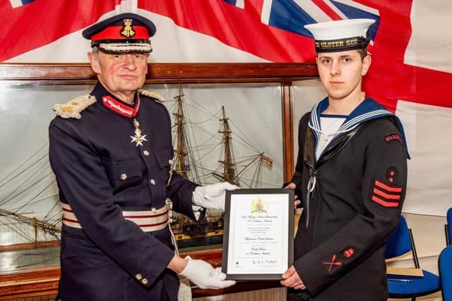 Teenage Sea Cadet Adam Barr receives his honour from Mr David McCorkell, Her Majesty's Lord Lieutenant for County Antrim