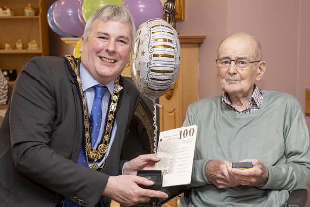 Bertie Watson receives his special Platinum Jubilee gift from the Mayor of Causeway Coast and Glens Borough Council, Councillor Richard Holmes, at his residence at Brookmount Nursing Home, Coleraine