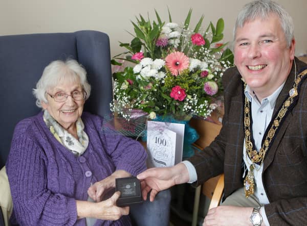 Greta Wilson receives a bespoke glass paperweight as part of Causeway Coast and Glens Borough Council’s Platinum Jubilee gift initiative from the Mayor, Councillor Richard Holmes
