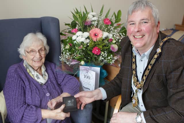 Greta Wilson receives a bespoke glass paperweight as part of Causeway Coast and Glens Borough Council’s Platinum Jubilee gift initiative from the Mayor, Councillor Richard Holmes