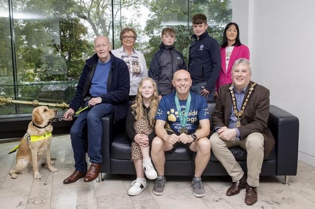 The Mayor of Causeway Coast and Glens Borough Council, Councillor Richard Holmes (front-right), recently held a special reception for local athlete, Jim Bradley (front-centre). They were joined by Jim’s close friend Iain Matthew (front-left), Iain’s family and his guide dog Mac. Jim is currently raising much needed funds for Guide Dogs NI by running a series of marathons