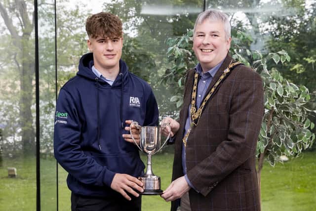 Tom Coulter (left) displays the Bain Dickinson trophy (awarded for his achievement in youth sailing) at a recent reception held in his honour by the Mayor of Causeway Coast and Glens Borough Council, Councillor Richard Holmes