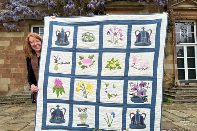 Christine Grant from Historic Royal Palaces with the hand-stitched quilt made by volunteer, Susan Mathieson.