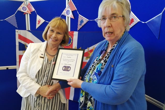 At the Crumlin WI Jubilee celebration President Iris Graham presenting Ruth Graham with honorary membership. in recognition of her long service to Crumlin W.I., Lisnagarvey Area, the Federation and the International Committee