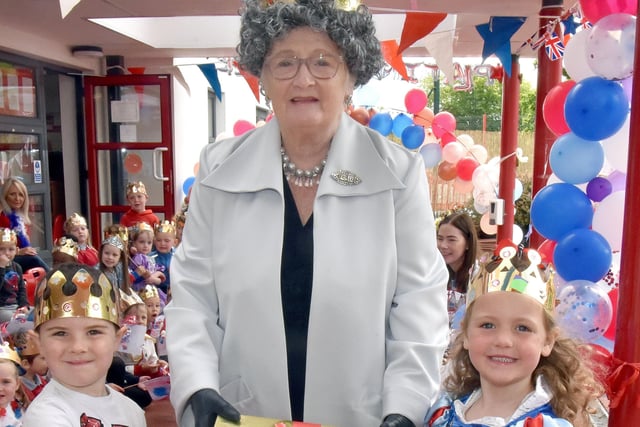 Freddie McClelland and Ezaria Geddis present a gift to 'The Queen' during her visit to Millington Nursery School. INPT22-221.