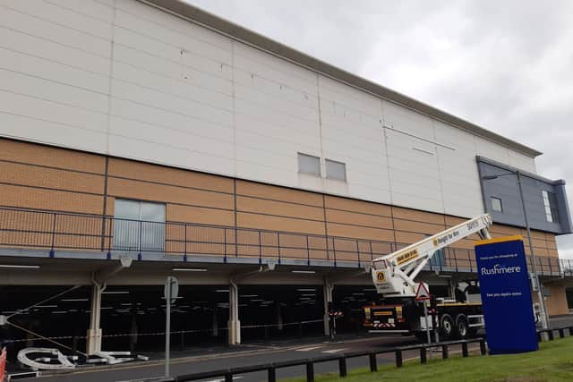 The old Debenhams sign at Rushmere Shopping Centre in Craigavon, Co Armagh is removed by workmen today.