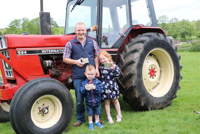Proudly displaying the special plaques awarded to all participants are William McKeown from Dromara with his daughter Liliana(6) and William junior who is 3. They were taking part in the Tractor Run organised by the Dromara Vintage and Classic Club in aid of the Daisy Lodge centre for children with cancer.