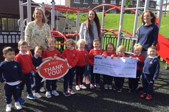 Mrs Helen Malcolm, Grace Williams (Area Fundraising Manager for Air Ambulance NI) and Principal Tracey Cassells with pupils from Barbour Nursery School