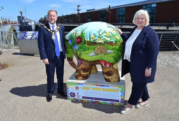 Mayor of Antrim and Newtownabbey Alderman Stephen Ross pictured with NI Hospice Chief Executive Heather Weir at the Council’s Elmer sculpture, beside the HMS Caroline at Belfast Harbour.