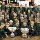 CUPS OF CHEER. Pictured on Wednesday are pupils from St Brigid's PS Ballymoney along with the Christie Ring and Ulster Championship cups won by Antrim.BM46-008SC.