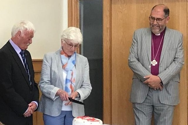 Bishop George Davison watches Aubrey Sweeney and Linda Tissington cutting the bicentenary cake