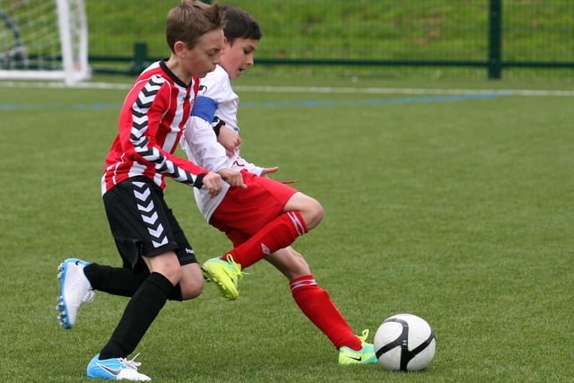 Maiden City Academy’s Marc Dixon fends of a challenge from  Tristar’s Caoimhin Hone,  during action in their under 10 game in the Foyle cup tournament at Leafair.  INLS 1230-516MT.