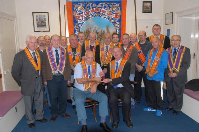 Harry Carter, the Worshipful District Master of Larne District LOL No 1, presents a 50-year jewel to Joe McConnell, Secretary of Larne LOL No 884 in 2013. With them are Joe's fellow LOL lodge members during the meeting in the Victoria Orange Hall. Picture: Peter Rippon.