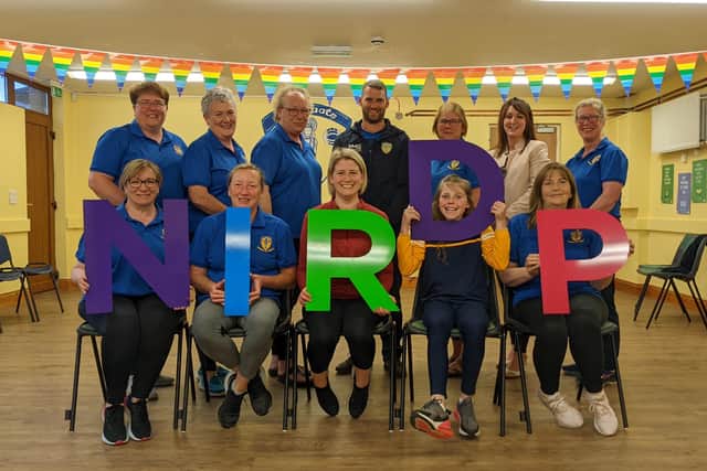 Members of Maggie's family, Sheenagh, Eimear and Jervis, the ladies from the St Ergnat’s Mothers and Others Group and Anne Marie O’Loan, NIRDP Tteasurer and Rhoda Walker, volunteer.