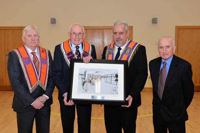 Former Mayor of Larne Tom Robinson (right) hosted a private dinner where Braid District LOL No18 members, William Smyth and Dessie Gray presented a painting to Sir William Wright in recognition of receiving the honour of Knight Bachelor of the British Empire. INLT 48-001-PSB