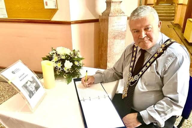 The Mayor of Causeway Coast and Glens Borough Council Councillor Ivor Wallace signs the Book of Condolence for Lord Trimble in Coleraine Town Hall