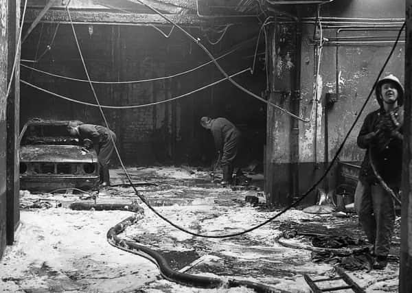 News Letter staff clearing up the garage where the accidental fire was believed to have started in April 1980. Picture: News Letter archives