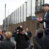 Jamie Bryson speaks to the gathered crowd outside Newtownards PSNI Station during a recent protest.