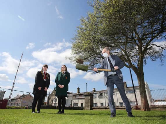 Education Minister Peter Weir visiting Limavady Shared Education Campus to cut the first sod on the new £11 million scheme. Looking on are students  Leah Craig and Clara Clements.