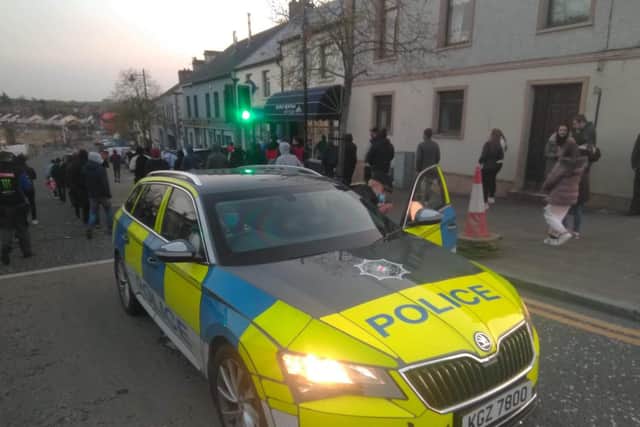 Protestors in Markethill last night walk past a PSNI car