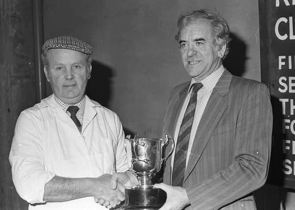 Ulster Farmers' Union president John Warden presents the DANI Cup to Bertie Kerr of Ballymoney, exhibitor of the best performance-tested boar at the show and sale of pedigree pigs which was held at Balmoral in March 1991. Picture: Farming Life archives