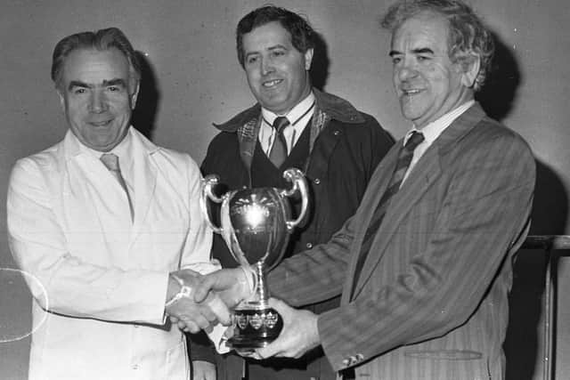 Robert Overend, left, from Bellaghy receives the PPDC Cup for best Red Star boar from UFU president Johm Warden at the show and sale of pedigree pigs which was held at Balmoral in March 1991. Included is Jack Collins, centre, from Belfast, who was one of the judges. Picture: Farming Life archives
