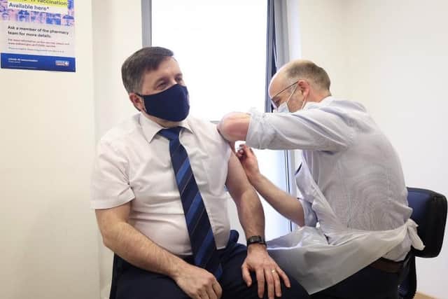 Health Minister, Robin Swann MLA receives his first Covid-19 vaccine from Stephen Burns, community pharmacist at Ballee Pharmacy, Ballymena.