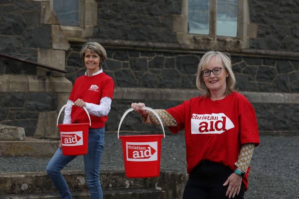 Friends Louise McGregor (left) and Susan Wilson prepare to walk for 5 kms while carrying buckets of water, in solidarity with women and girls in drought-affected parts of rural Africa who walk for hours each day to fetch water for their families and livestock