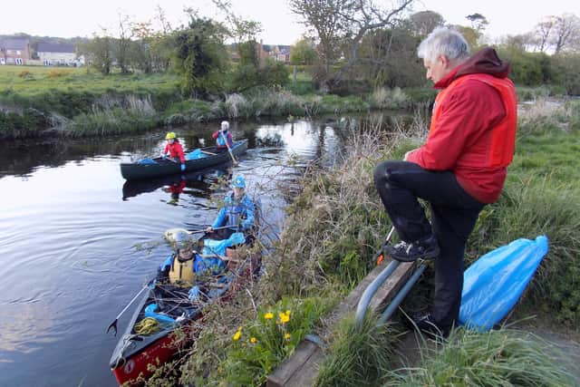 Dougie Tyler from CAPS looks on as Marion Dornan and Callum Corr (red canoe) and Claire and Niamh Corr (green canoe) remove some of the litter on the Braid River