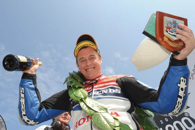 Honda TT Legends rider John McGuinness celebrates winning the opening Superbike race at the 2012 North West 200.