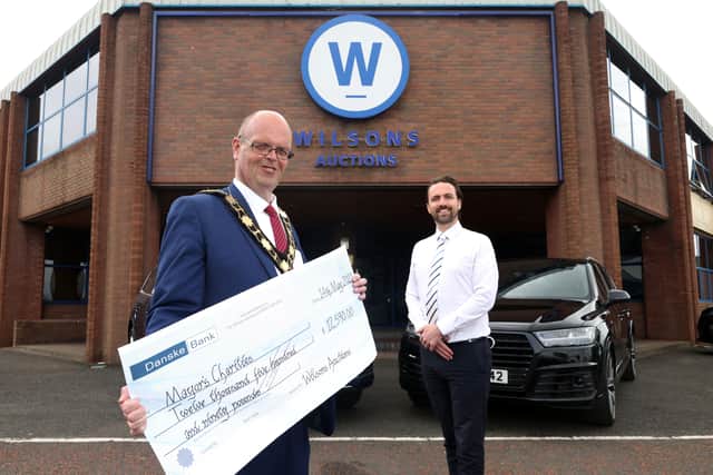 John Ardill, General Manager of Wilsons Auctions presents a cheque totalling £12,590 to Mayor of Antrim and Newtownabbey, Councillor Jim Montgomery for proceeds raised from his online charity auction.
