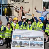 Pupils from Phoenix Integrated Nursery and Primary School along with Mrs Heather Watson (Principal) and Mrs. Liz Simpson (Chair of Board of Governors) examine the plans for a new school building on the current site.