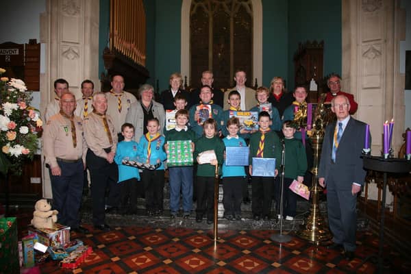 Members of the Co Londonderry Boy Scouts, and their leaders, who presented gifts to Anita Denvir of Dr Banardos, Mr Mrs Capt Archibald The Salvation Army, Margaret McLaughlin, and Sean ONeill, from St Vincent De Paul, with Cannon Sam McVeigh of Christ Church Limavady.50a043nbt