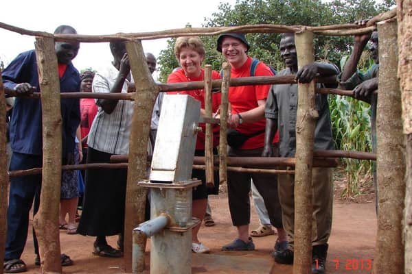 Dr Dickie Barr with his wife Janice at the borehole built with the help of Charlene's Project in Uganda