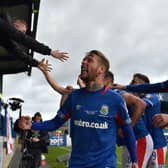 Kirk Millar and Linfield players share in the celebrations with supporters inside Mourneview Park. Pic by Pacemaker.