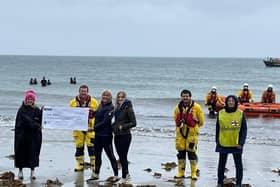 Some of Larne RNLI’s volunteer crew and members of the fundraising team are presented with a cheque for £1,016 by the Chilli Dippers at Ballygally beach