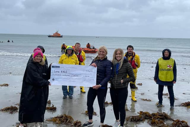 Some of Larne RNLI’s volunteer crew and members of the fundraising team are presented with a cheque for £1,016 by the Chilli Dippers at Ballygally beach
