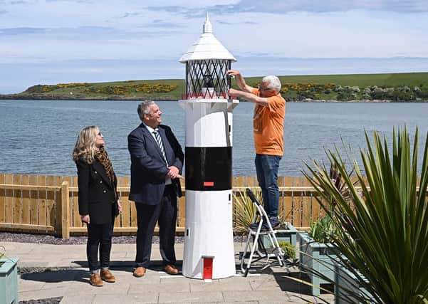 Looking on as charity volunteer Sam McCullough makes a final adjustment to the lighthouse, are David Savage, Governor Maghaberry Prison and Dawn McConnell, Founder of the Hope House charity. Picture: Michael Cooper