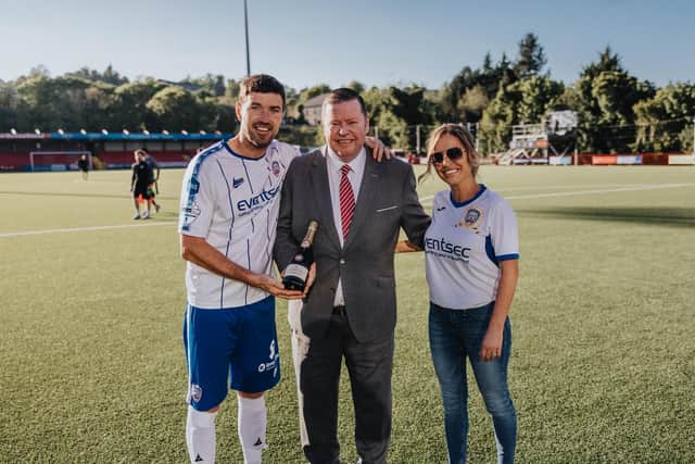 Steven Douglas pictured with his wife Paula receiving a bottle of champagne from Larne FC chairman Gareth Clements. PICTURE: David Cavan