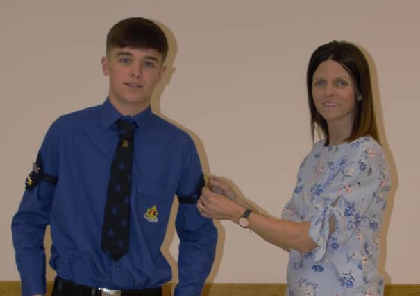 Sam Reid being presented with his Queen's badge by his mum Ann
