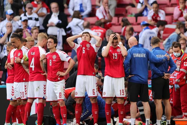 Denmark's players react as paramedics attend to Denmark's midfielder Christian Eriksen after he collapsed on the pitch during the UEFA EURO 2020 Group B football match between Denmark and Finland at the Parken Stadium in Copenhagen on June 12, 2021. (Photo by FRIEDEMANN VOGEL/POOL/AFP via Getty Images)