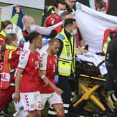 Denmark’s Christian Eriksen (hidden) leaving the pitch on Saturday after life-saving pitchside treatment. Pic by PA.