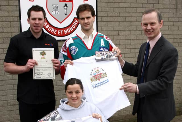 Noel Gormley, proprietor of the Streat Cafe, sponsor of tickets for Carniny Primary School pupils visit to the Belfast Giants hockey match pictured with Giants player Todd Helman presenting Michelin sponsored Say No to Bullying tee shirts to the school's Principal Mr. R. Ross and Mrs. Louise Creighton. BT8-007JM.